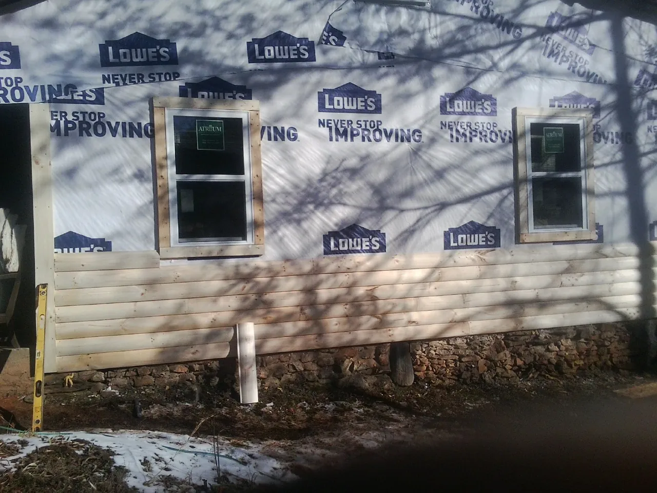 House wrap and new log siding going up on an exterior wall in Washington Court House