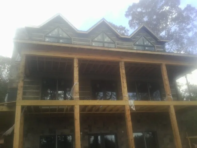 Dormers and porch framing on a large log home under construction — Roof Coating work by our crew in Washington Court House