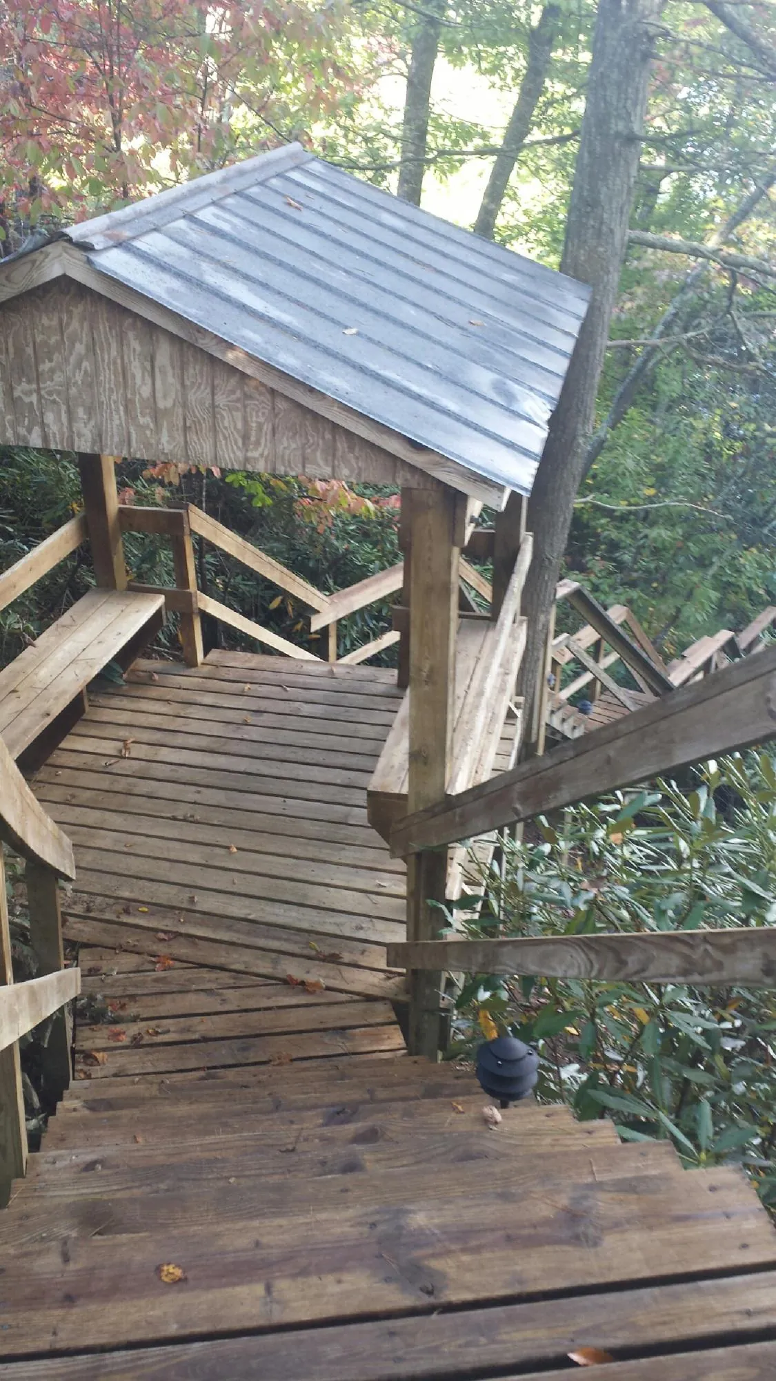 Metal roofed shelter over wooden steps on a wooded walkway — Skylight Repair & Installation work by our crew in Washington Court House