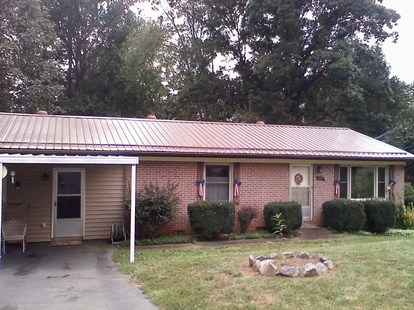 Bronze metal roof and carport on a brick ranch home — Roof Repair work by our crew in Washington Court House